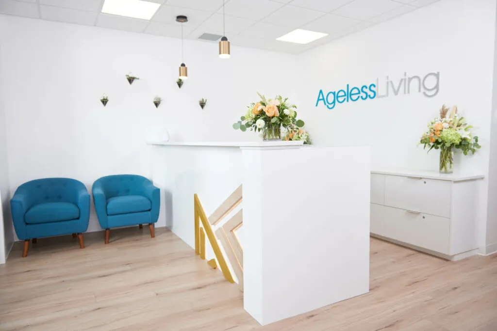The Ageless Living reception, with pale oak floors, blue armchairs and fresh flowers