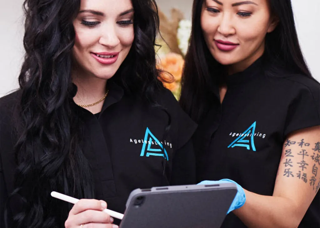 Two Ageless Living clinicians reviewing an intake together on a tablet
