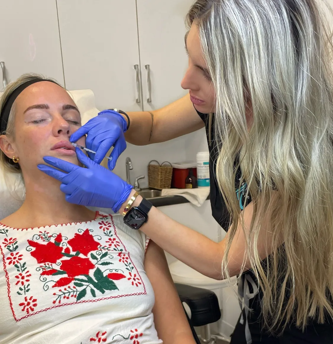An Ageless Living injector placing dermal filler in a patient’s lip